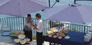 Billede fra Italiensk ferie. Billedet viser to tjenere, der står med italienske specialiteter.