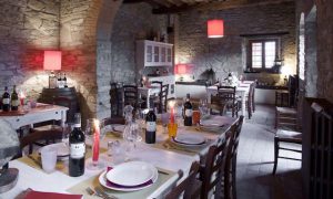 Restauranter i italien. Italiensk villa med opdækket spisebord. Hyggelig italiensk stil med vin og levende lys.