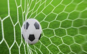 Billede af en fodbold, der bliver skudt i et net.